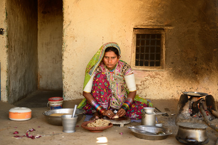 BHUJ, INDIA - JANUARY 13: The ethnic woman in the village on the desert in the Gujarat state is preparing the cake to pies chapati in the kitchen by oneのeditorial素材