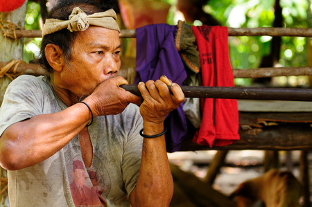 LONG COP BORNEO INDONESIA JUNE 06: Native American hunting in the jungle on an island of Borneo with blowgun with poisoned arrows Long Poso on June 06 2011のeditorial素材
