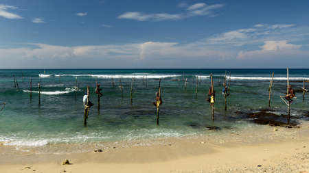 GALLE, SRI LANKA - MARCH 02:Fishermen on stilts trying to catch a fish on the pole on the coast of Sri Lanka. Galle on March 02, 2015のeditorial素材