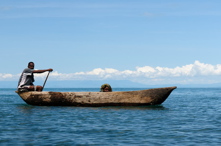 MATEMA, TANZANIA - APRIL 29: Natives from above the lake Malawi swimming in the traditional canoe made of the one-piece tree mango in Tanzania, Matema in April 29, 2013のeditorial素材