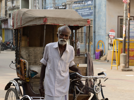 INDIA, MADURAJ - MARCH 05: Rickshaw driver with one's rickshaw in the street of Indian city, Maduraj in March 05, 2015のeditorial素材