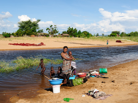 IKOLA, TANZANIA - MAY 07: The African family on the Tanganyika lake is taking a bath, is washing and is washing up in Tanzania, Ikola in May 07, 2013のeditorial素材