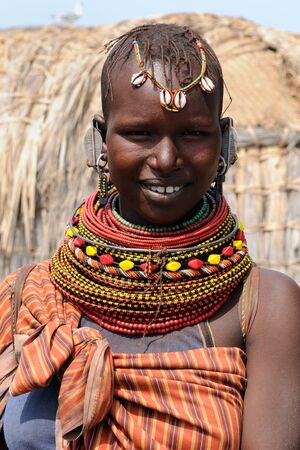 KOMOTE, KENYA - JULY 12: African woman from the Turkana tribe in the traditional dress in transit to the market in Kenya, Komote in July 12, 2013のeditorial素材