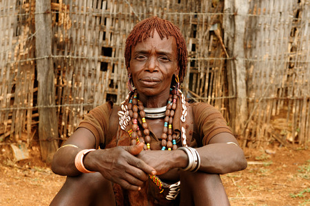 Portrait of the woman from Hamer people resting by the fence in transit to the local marketplace in Dimeka, Omo valleyのeditorial素材