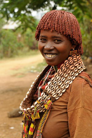 Portrait of the woman from Hamer people resting by the fence in transit to the local marketplace in Dimeka, Omo valleyのeditorial素材