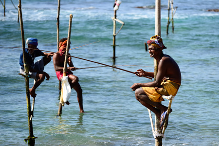 GALLE, SRI LANKA - MARCH 02:Fishermen on stilts trying to catch a fish on the pole on the coast of Sri Lanka. Galle on March 02, 2015のeditorial素材
