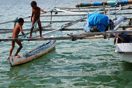 KOMODO, INDONESIA - APRIL 19:The two of Indonesian boys is enjoying itself at a fishing boat of its father on an island Komodo in Indonesia, Komodo on April 19, 2011のeditorial素材