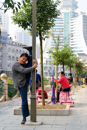 GUILIN, CHINA - NOVEMBER 14: Chinese man making of exercising on the streets of the large Chinese city Guilin on November 14, 2010のeditorial素材