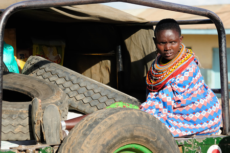 MARARAL, KENYA - JULY 03: African woman from the Samburu tribe with characteristic decorative necklaces is waiting for the transport by jeep to one's village in the bushon near the Mararal town in Kenya, Mararal in July 03, 2013のeditorial素材