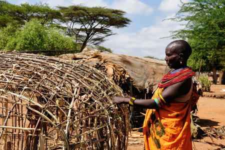 SOUTH HORR, KENYA - JULY 07: African woman  with characteristic decorative necklaces from the Samburu tribe in the traditional dress he is building his house in Kenya, South Horr in July 07, 2013のeditorial素材