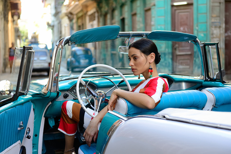 HAVANA, CUBA - 11 DECEMBER 2016: The beautiful Cuban woman is getting the classical American car off in the centre of old Havana on Cubaのeditorial素材