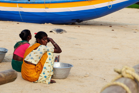 PURI, INDIA - 19 DECEMBER 2009: Poor Indian fishermen are waiting on the beach for the boats returning from the fishingのeditorial素材