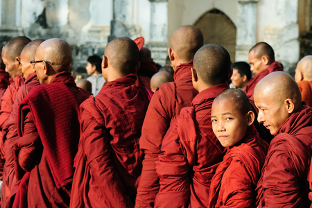 BAGAN, MYANMAR - 19 JANUARY 2011: Young Buddhist monks standing in a queue for giftsのeditorial素材