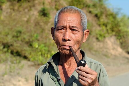BAGAN, MYANMAR - 24 JANUARY 2011: Portrait of the Burmese smoking a pipeのeditorial素材
