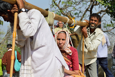 PALITANA, GUJARAT, INDIA - JANUARY 25: Indian pilgrims carried on primitive sedan chairs to the holy Palitana top in the Gujarat state in India, Palitana in January 25, 2015のeditorial素材