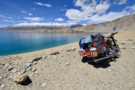 TSO MORIRI, JAMMU AND KASHMIR, INDIA - 05 JULY 2017: Motorbike Royal Enfield standing by the Tso Moriri Lake in the Karakorum Mountains near Leh, India. This region is a purpose of motorcycle expeditions organised by Indiansのeditorial素材