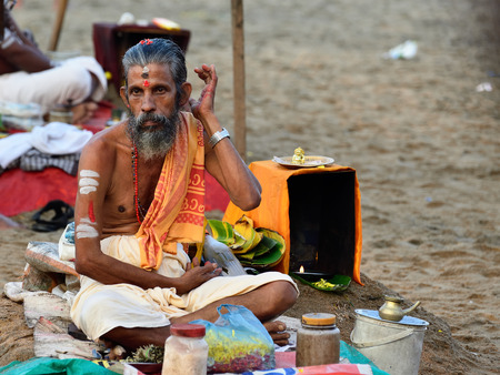 VARKALA, KERALA, INDIA - 18 MARCH 2015: Traditional morning Puja  in the holy place on Varkali beaches in the Kerala state in India. Brahmin waiting for pilgrimsのeditorial素材
