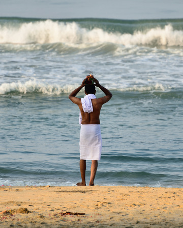 VARKALA, KERALA, INDIA - 18 MARCH 2015: Traditional morning Puja  in the holy place on Varkali beaches in the Kerala state in India. Pilgrims walk down to the sea to offer pujaのeditorial素材
