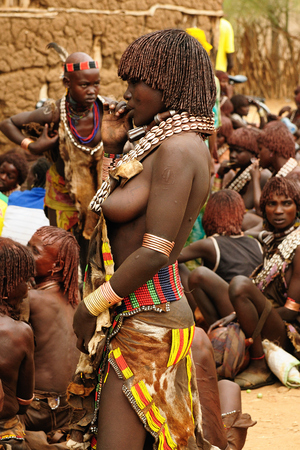 TURMI, OMO VALLEY, ETHIOPIA - 29 JULY 2013: Ethiopian people from Hamer people being a local ethnic market trader in Turmiのeditorial素材