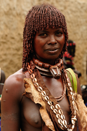 TURMI, OMO VALLEY, ETHIOPIA - 29 JULY 2013: Ethiopian people from Hamer people being a local ethnic market trader in Turmiのeditorial素材