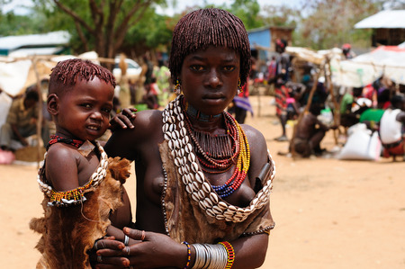 TURMI, OMO VALLEY, ETHIOPIA - 29 JULY 2013: Portrait of the woman with the small child on the hand from Hamer people on the local marketplace in Turmi, Omo valley in July 29, 2013のeditorial素材