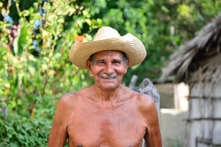 LAS CUEVAS, SANTIAGO DE CUBA, CUBA - 25 NOVEMBER 2016: Cuban farmer standing in front of his house in the mountains Sierra Maestra on Cubaのeditorial素材