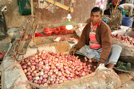 DHAKA, BENGAL BANGLADESH - 26 JANUARY 2019: Man peeling onion on the vegetable market in the capital city of Bangladesh for Dhakaのeditorial素材