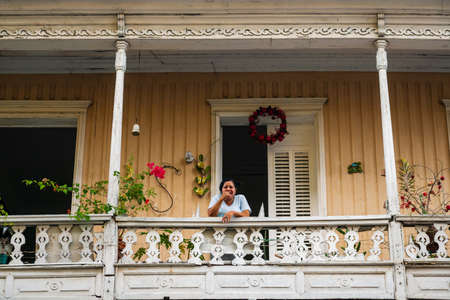 SANTIAGO DE LOS CABALLEROS, DOMINICAN REPUBLIC - 13 DECEMBER 2017: The resident of Dominican Republic looks to the street from balconies of the colonial house in the capital city of cultural Dominicaのeditorial素材