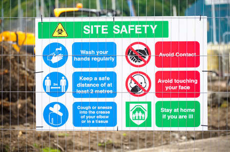 Construction site health and safety message rules sign board signage on fence boundaryの写真素材