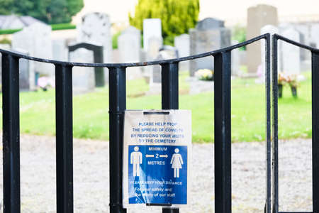 Social distancing sign at graveyard gate for visitorsの写真素材