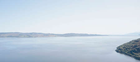 Mindfulness calm background banner of aerial view from above loch in moody sunrise sky in Scotlandの写真素材