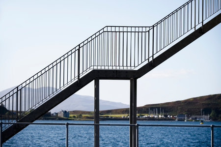 Metal stair silhouette and rail diagonal rising upwards at ferry portの写真素材