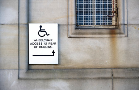 Disabled accessible push button buzzer for assistance sign at building entrance