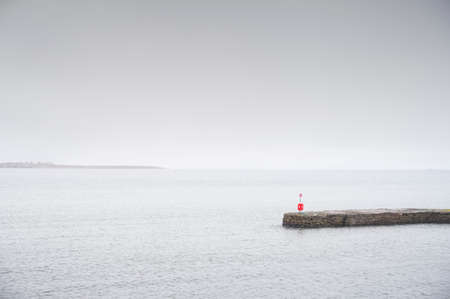 Tranquil peaceful water stone jetty pier at lakeの写真素材