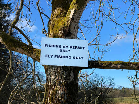 Fishing permit only warning sign at private lake and loch in countryside