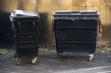 Black litter bins on wheels for rubbish in public housing estateの写真素材