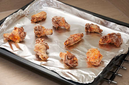 Frozen chicken wings on tray ready for cooking in ovenの写真素材