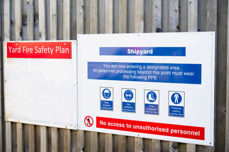Shipyard health and safety message rules sign board signage on fence boundary