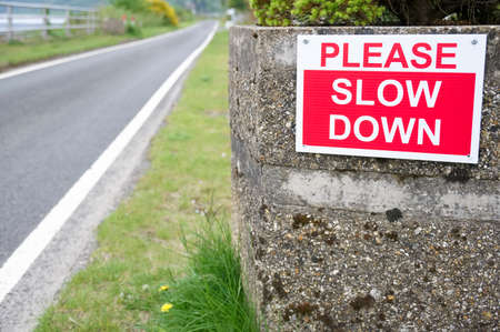 Slow down road sign at entrance to rural country villageの写真素材