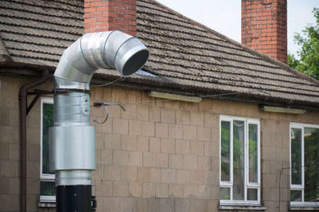 Flue chimney fixed to building exterior wall stainless steel from exhaust boiler plant room