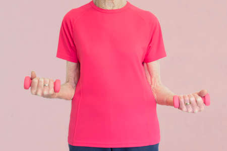 Senior elderly woman weightlifting with pink dumbbells