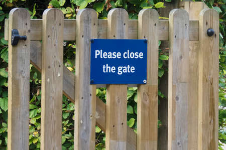 Please close gate sign on wooden fence at. childrens play parkの写真素材