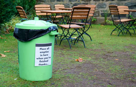 Green bin at outdoor cafe for garbage collection to keep area cleanの写真素材