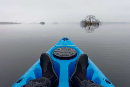 Blue kayak on open water in fog and mist at Loch Lomondの写真素材