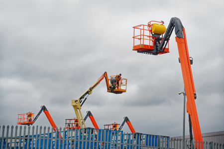 Glasgow, Scotland, UK, August 6th 2022, Access platform equipment powered high in sky at construction building siteのeditorial素材