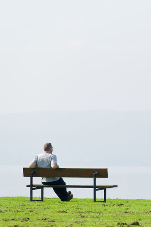 Man sitting alone on seat relaxing with sea viewの写真素材