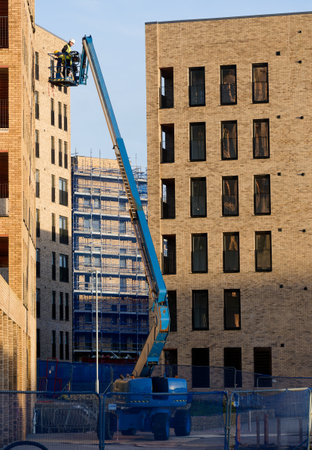 Glasgow, UK, 13th January 2024, Scissor lift being operated by construction workmen for safe access...
