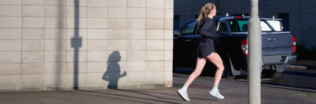 Single woman running early morning in urban environment