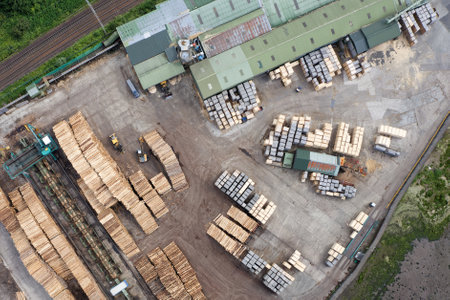 Sawmill with chopped wood logs stacked and machineryの写真素材