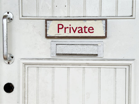 White door with private sign at rear of buildingの写真素材